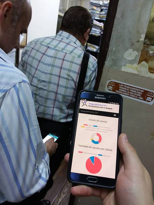celular mostrando software para abogados y gráficos informativos